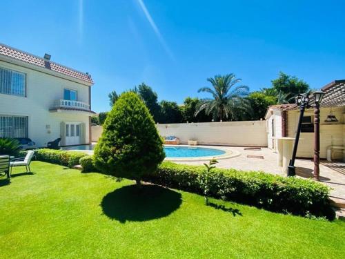 a yard with a swimming pool and a house at private Villa with a special view in Qaryat Shākūsh