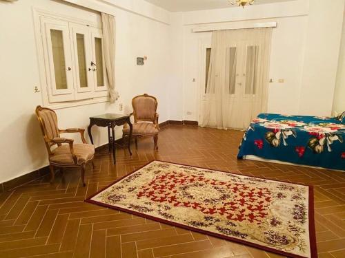 a bedroom with a bed and a table and a rug at private Villa with a special view in Qaryat Shākūsh