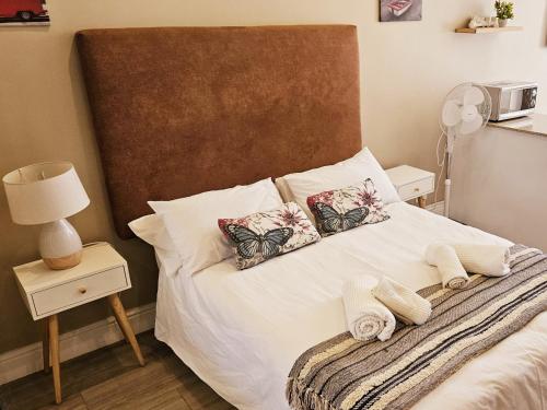 Un dormitorio con una cama blanca con dos almohadas. en Studio 37 Hyde Park Apartments, en Ciudad del Cabo