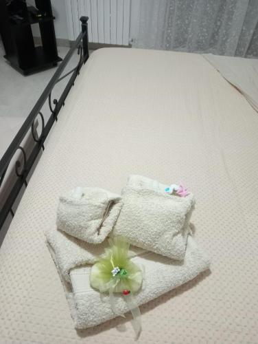- un lit avec des serviettes et une fleur dans l'établissement Casa Vacanza Luna2, à Palagiano