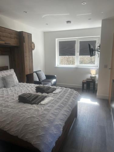 a bedroom with a bed and a couch and a window at Burnbrae Apartment in Portree