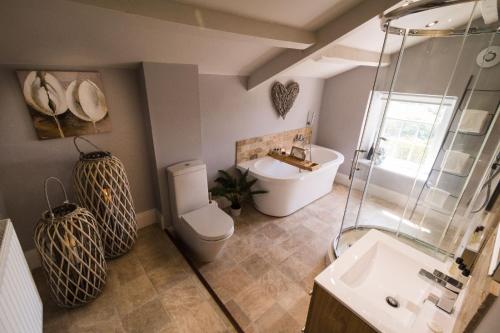 a bathroom with a shower and a toilet and a sink at Maison Cottage in Richmond