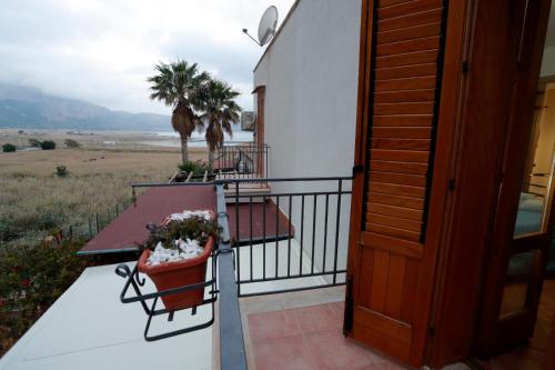 a balcony of a house with a table and plants at Rosa Di Makari in Macari
