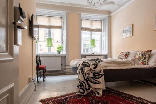 a living room with a couch and two windows at Castle House Inn in Stockholm