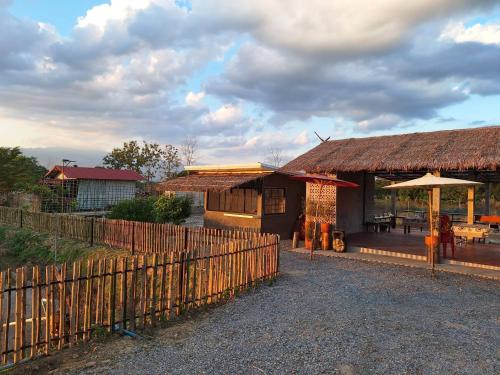 a house with a fence next to a building at Ha Me Garden ฮามีการ์เด้น โฮมสเตย์ฝาง in Fang