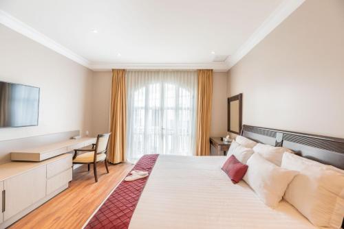 een hotelkamer met een groot bed en een bureau bij Grand Polanco Residencial in Mexico-Stad