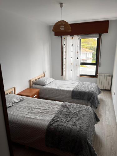2 letti in una camera con finestra di El apartamento de Xavi ad A Coruña