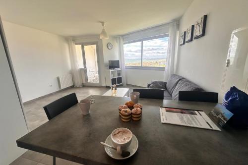 - un salon avec une table et un canapé dans l'établissement Le Soleil Couchant Studio Vue Mer, au Grau-du-Roi