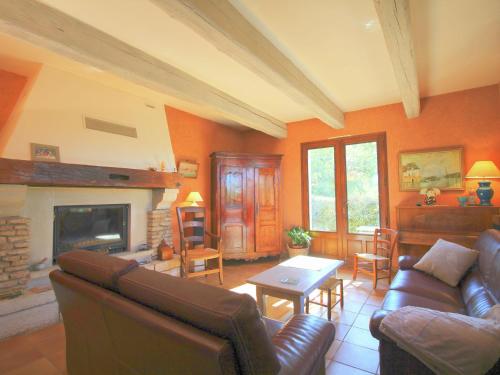 a living room with a couch and a fireplace at Detached holiday home with private pool in the village of Roussillon in Murs