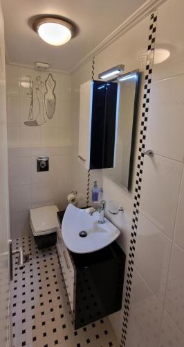 a bathroom with a white sink and a toilet at Place 2 Be in Nafpaktos