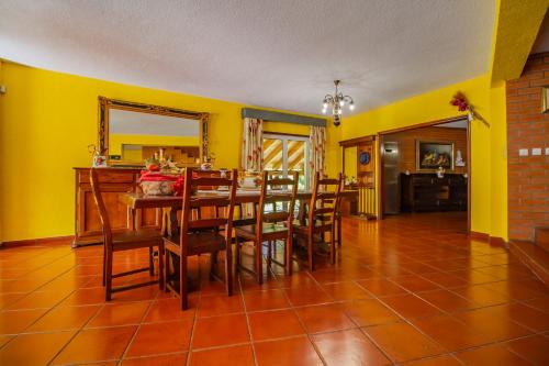 a dining room with yellow walls and a table and chairs at Quinta de São Francisco in Cinfães