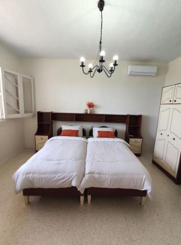 a bedroom with two beds and a chandelier at Wilga Summit Apartment C in Qala