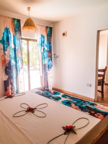 a bedroom with a bed with flowers on it at TIANDE Boutique Hotel in Pwani Mchangani