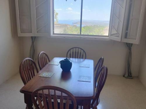 a table with chairs and a vase on top of it at Wilga Summit Apartment C in Qala