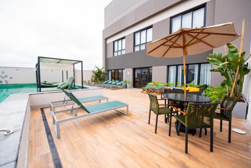 a patio with a table and chairs and an umbrella at EXCELENTE Studio V915 Vila Olímpia in Sao Paulo