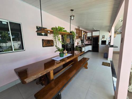 uma sala de jantar com um longo banco numa cozinha em Casa Rosa em Cuiabá