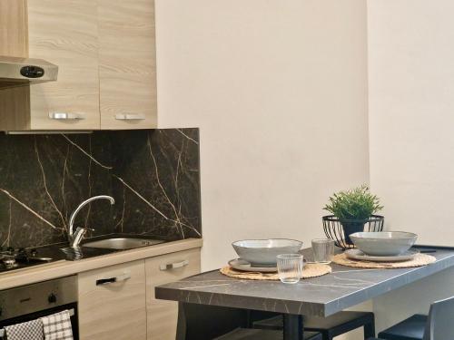 una cucina con tavolo e due ciotole sopra di Al Centro del Centro Apartment by TraMonti a L'Aquila