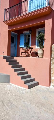 a pink building with stairs on the side of it at Aτos Comfort Villa in Asos