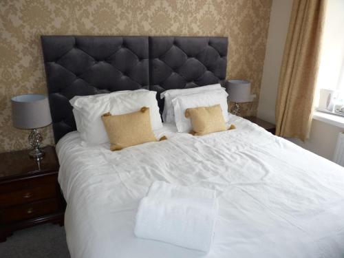 een groot wit bed met 2 kussens erop bij Seven Stars - Bed & Breakfast & Restaurant in Okehampton