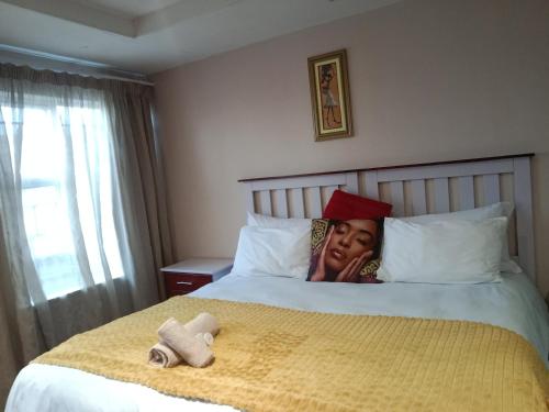 a woman laying on a bed in a hotel room at Edladleni Guesthouse Quigney in East London