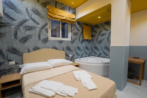 a bedroom with a bed and a bath tub at GreRos H. Porto Napoli Centro, by ClaPa Group Dislocated Hospitality in Naples