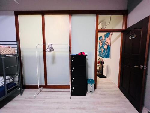 a room with a refrigerator and two bunk beds at 綠色的日子 in Nantou City