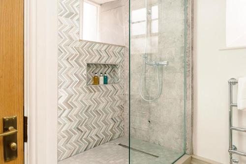 a shower with a glass door in a bathroom at The Manor House Hotel and Golf Club in Castle Combe