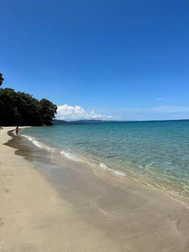 a person walking on a beach near the ocean at Villa Colibri - Private 1 bedroom Studio/Bachelor in Punta Uva