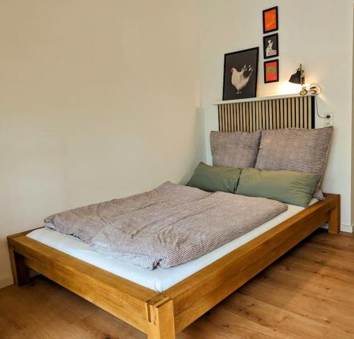 Apartment mit Balkon in Hannover-Ahlem في هانوفر: سرير مع اطار خشبي في الغرفة