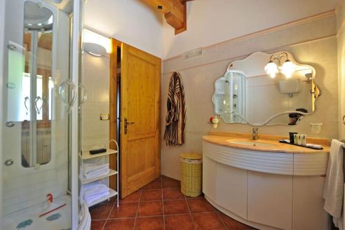 y baño con lavabo, espejo y ducha. en Villa Al Tramonto, en Lisciano Niccone
