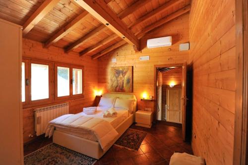 1 dormitorio con 1 cama en una habitación de madera en Villa Al Tramonto, en Lisciano Niccone