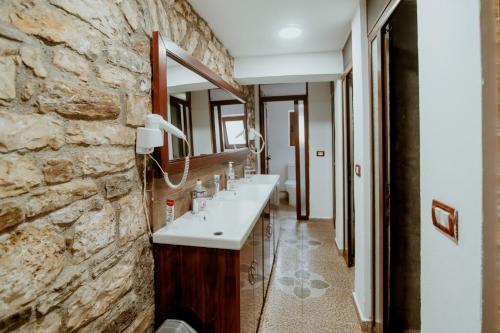 a bathroom with two sinks and a stone wall at Berat Backpackers Hostel in Berat