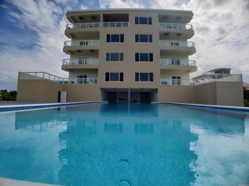 a hotel with a swimming pool in front of a building at Coconuts Caribe in San Pedro