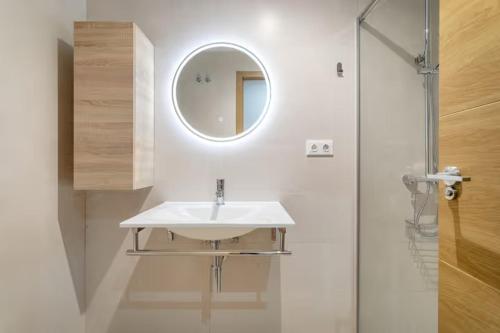 a white bathroom with a sink and a mirror at Precioso apartamento in Santa Pola