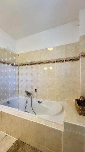 La salle de bains est pourvue d'une baignoire avec un mur en verre. dans l'établissement Maison en bord de mer, Plage de la Marana en Corse, à Borgo