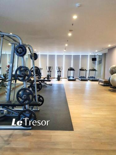 a gym with several tread machines in a room at Le Tresor Benson Apartment at Supermal Pakuwon in Surabaya