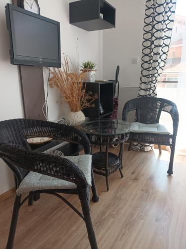 a living room with chairs and a table and a tv at Relaks w Marina Cape 88 in Aheloy