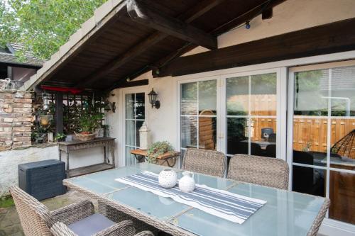 einen Glastisch mit Stühlen auf einer Terrasse in der Unterkunft Ferienhaus „große Familie“ in Zülpich