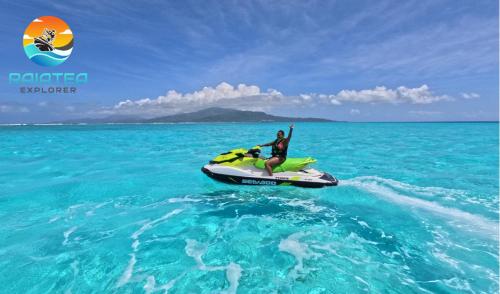 a man riding a jet ski in the ocean at Hutiarii house & car & excursions Raiatea in Tevaitoa
