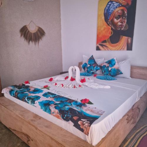 a bed in a room with a painting on the wall at TIANDE Boutique Hotel in Pwani Mchangani