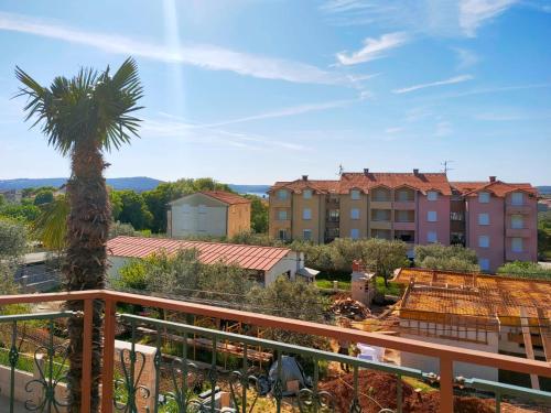 balkon z palmą i budynkiem w obiekcie Skajla Apartments w Medulinie