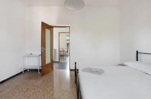 Dormitorio blanco con cama y mesa en Casa vacanze il Melograno en La Spezia