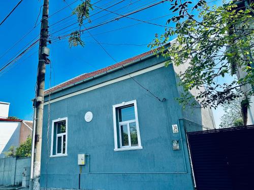 a blue house with a white window on a street at Serbian House in Timişoara