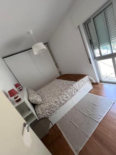Habitación pequeña con cama y escritorio. en Apartamento acolhedor em Queluz, en Queluz