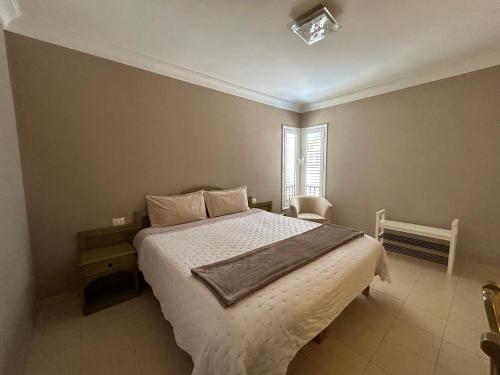 une chambre avec un lit avec des draps blancs et une fenêtre dans l'établissement Hermosa vista, à Puerto de la Cruz