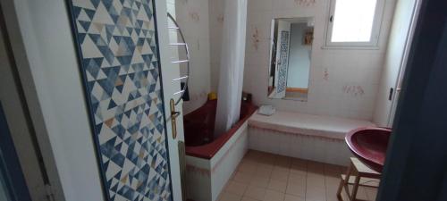 ein Badezimmer mit einer roten Badewanne und einem Waschbecken in der Unterkunft Maison de vacances avec piscine et jardin in Bompas