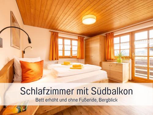 Biohof Burger, 3 sonnige Fewo, alle mit Balkon, Spielzimmer, Grillhütte, 7 km vor Oberstdorf في بلوسترلانج: غرفة نوم بسرير في غرفة