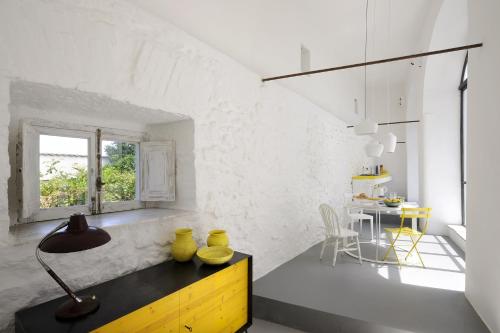 ein Zimmer mit einem Tisch mit gelben Vasen darauf in der Unterkunft Capri Kronos GuestHouse in Anacapri