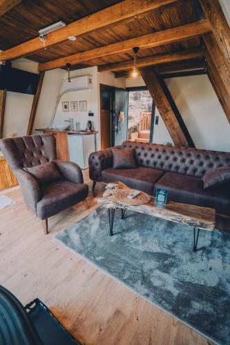 a living room with two leather couches and a coffee table at Montana Suite Bungalows in Trabzon
