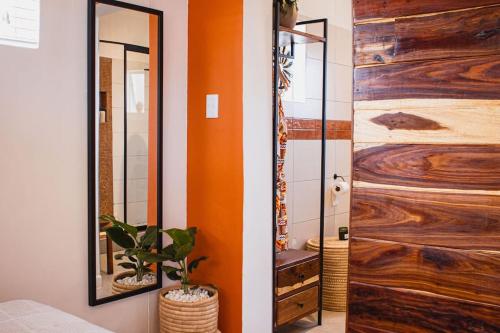 a bathroom with a wooden door and a mirror at Garden Oasis in Windhoek